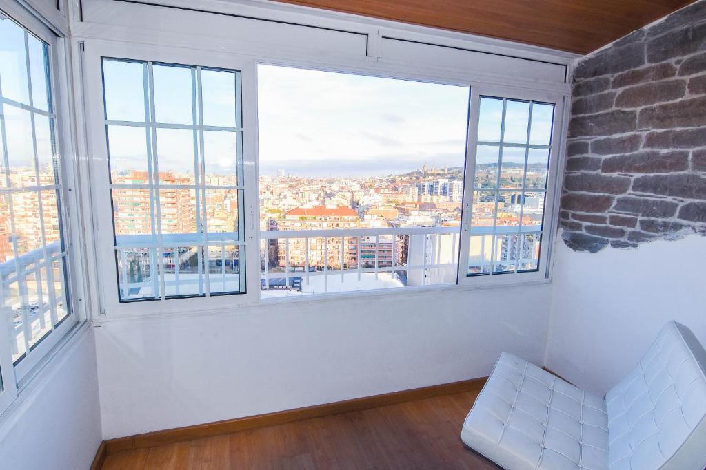 a white room with large windows with a view at Touch the sky BCN in Hospitalet de Llobregat