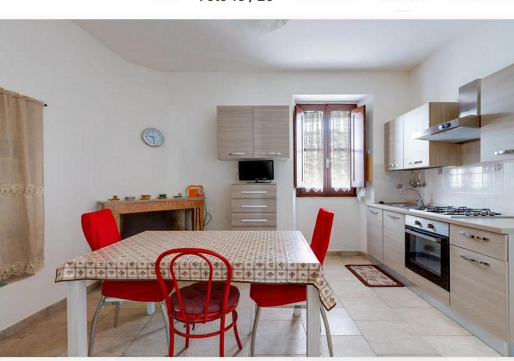 una cucina con tavolo e sedie rosse di Casa vacanze Oristano Ghilarza Sardegna a Ghilarza