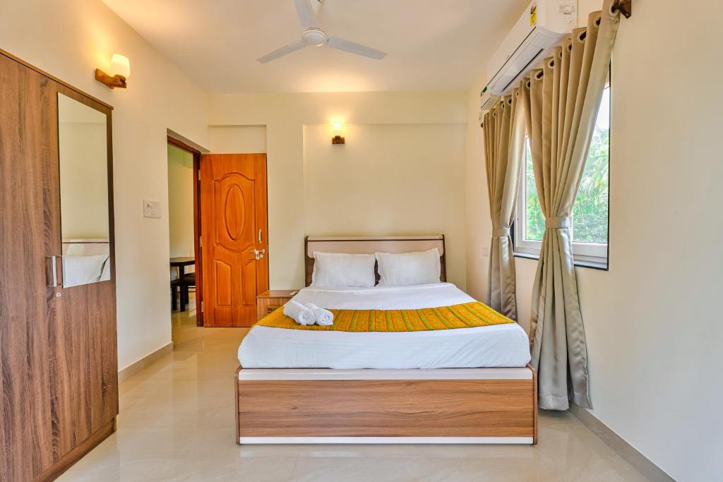 a bedroom with a bed and a window at Golden Sun Ray's Villas in Baga