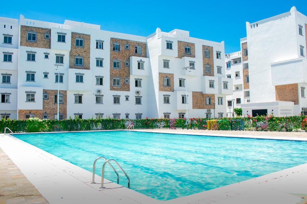 une grande piscine en face des bâtiments dans l'établissement A Cozy 3 Bedroom Apartment With a Pool in Mombasa, à Mombasa