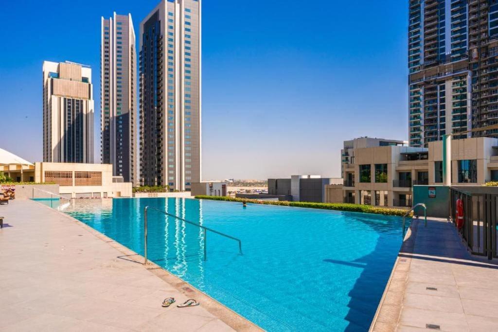 杜拜的住宿－2bdr - Pool - Emaar - Creek Harbour，一座位于城市的游泳池,有高大的建筑