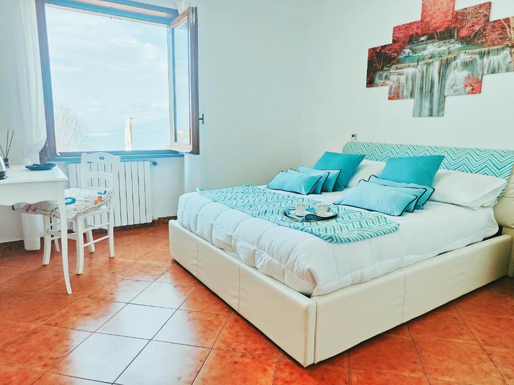 - une chambre avec un grand lit et des oreillers bleus dans l'établissement Camera Panoramica in Villa vista Mare e Vesuvio, à Massa Lubrense