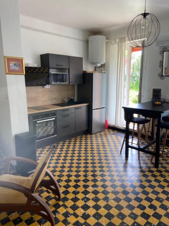 eine Küche mit einem Tisch und einem Esszimmer in der Unterkunft Légèreté aux Mûriers in Le Lavandou