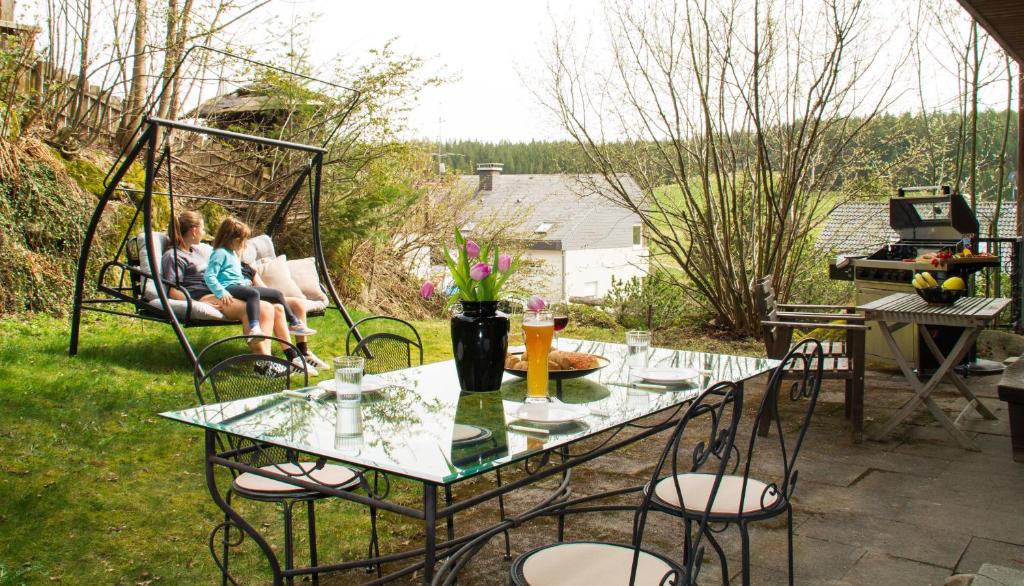 two women sitting at a table on a patio at Ferienwohnung in Schönwald Schwarzwald in Schönwald