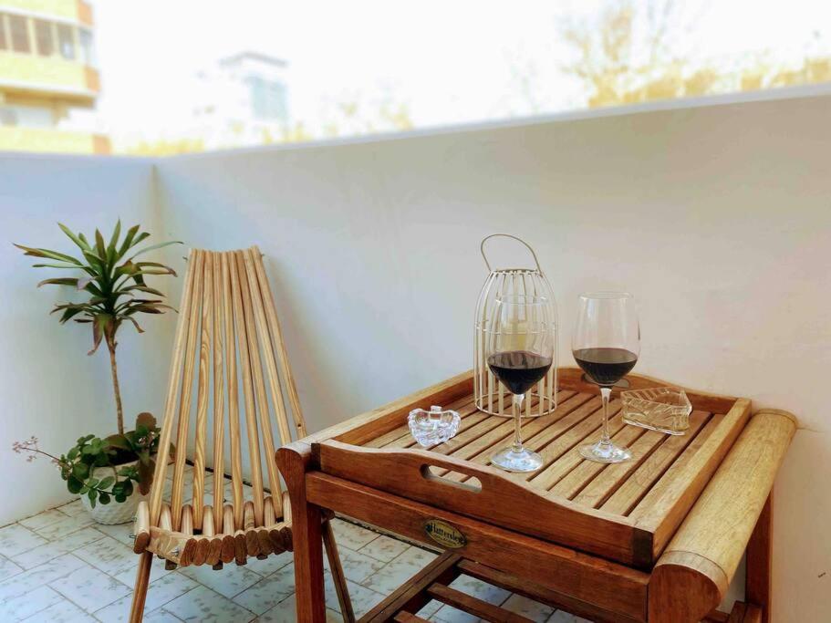 a table with two glasses of wine on a balcony at Pampa Downtown Lodge in Mendoza
