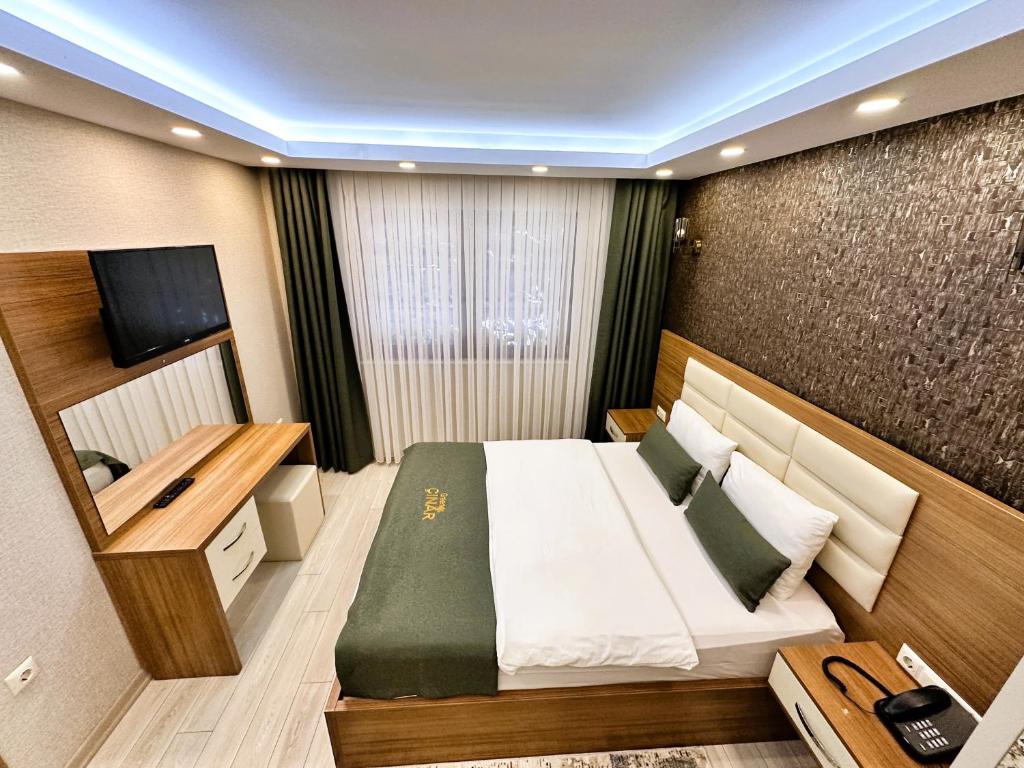 um quarto de hotel com uma cama e uma televisão em Green Cinar Apart em Uzungol