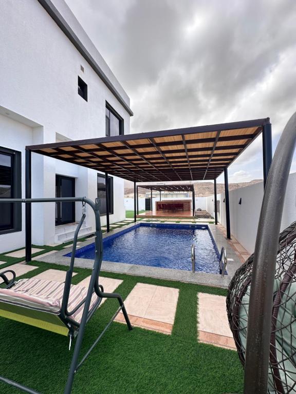 a swimming pool in a house with awning over it at Dibab house in Murrah