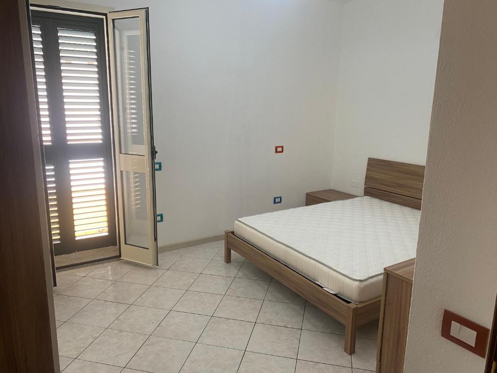 - une chambre avec un lit, une fenêtre et une porte dans l'établissement Trilocale in centro, à Castelsardo