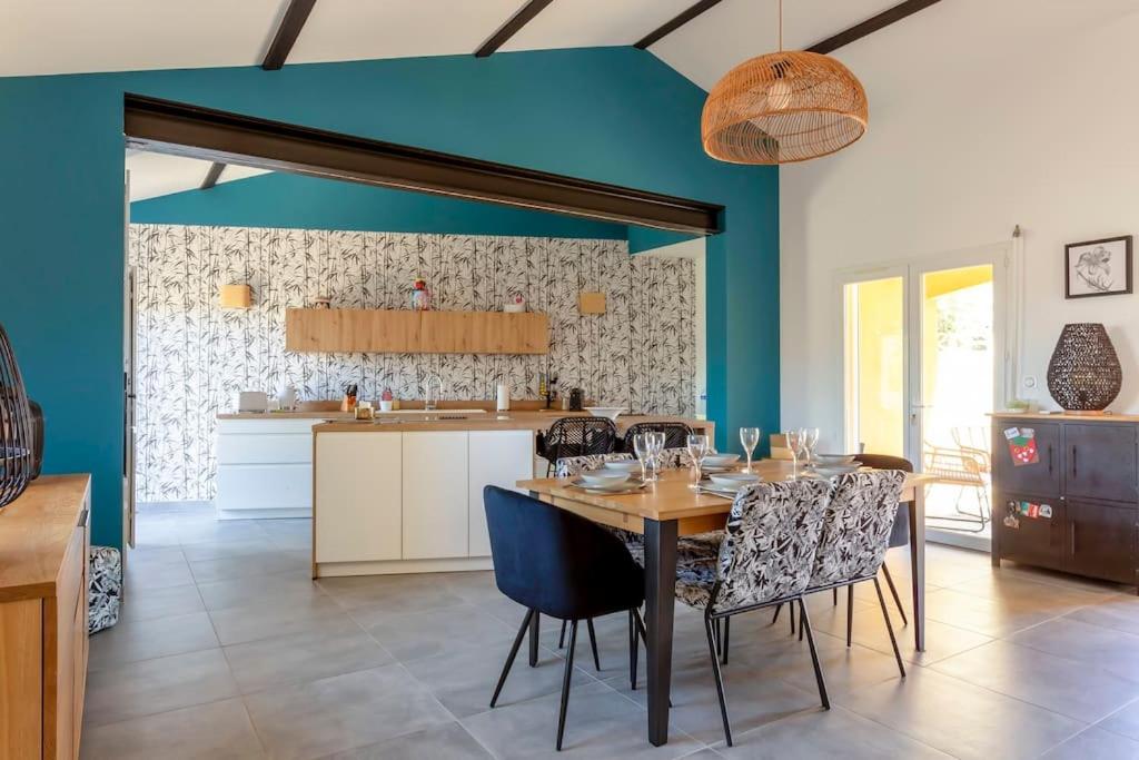 uma sala de jantar e cozinha com mesa e cadeiras em Chez Morgane - Superbe maison familiale proche des remparts em Aigues-Mortes