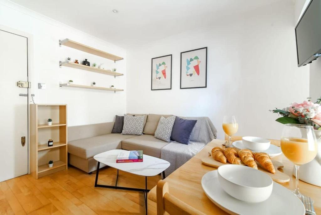 uma sala de estar com um sofá e uma mesa em Fitzrovia & Regent's Park - CityApartmentStay em Londres