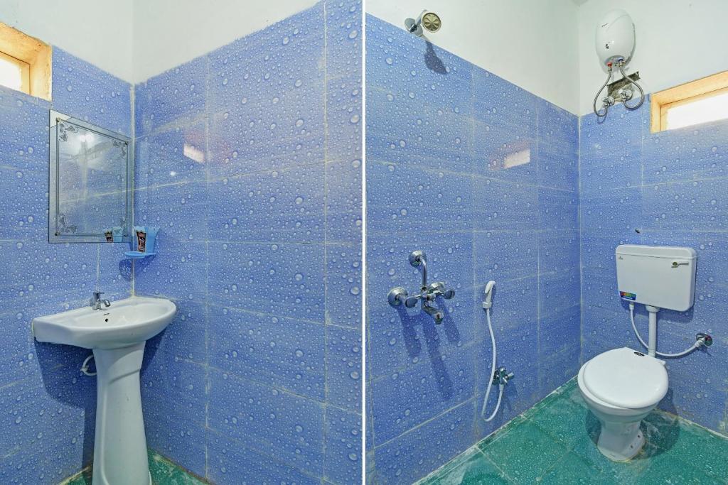 a blue tiled bathroom with a toilet and a sink at Flagship Ananta Palace in Bhubaneshwar