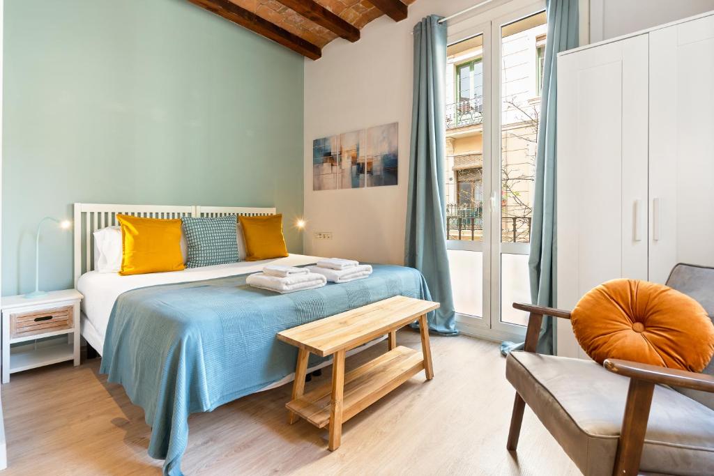 a bedroom with a bed with a table and a chair at Lodging Apartments Beach Studio 11 in Barcelona