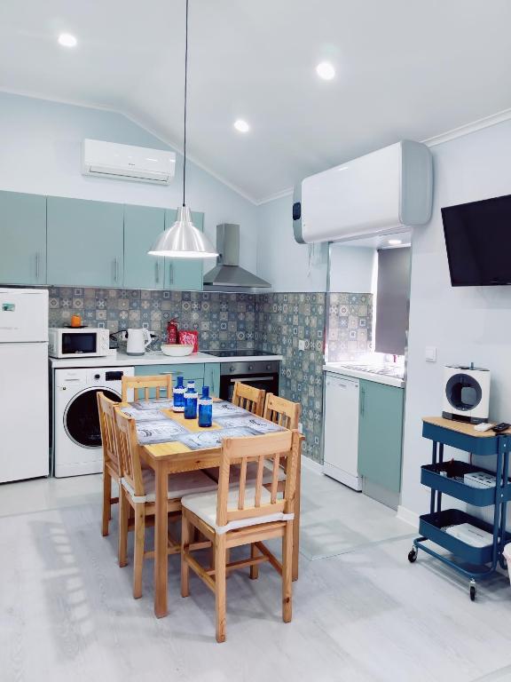 a kitchen with a wooden table and chairs at Riviera Beach A in Praia da Vitória