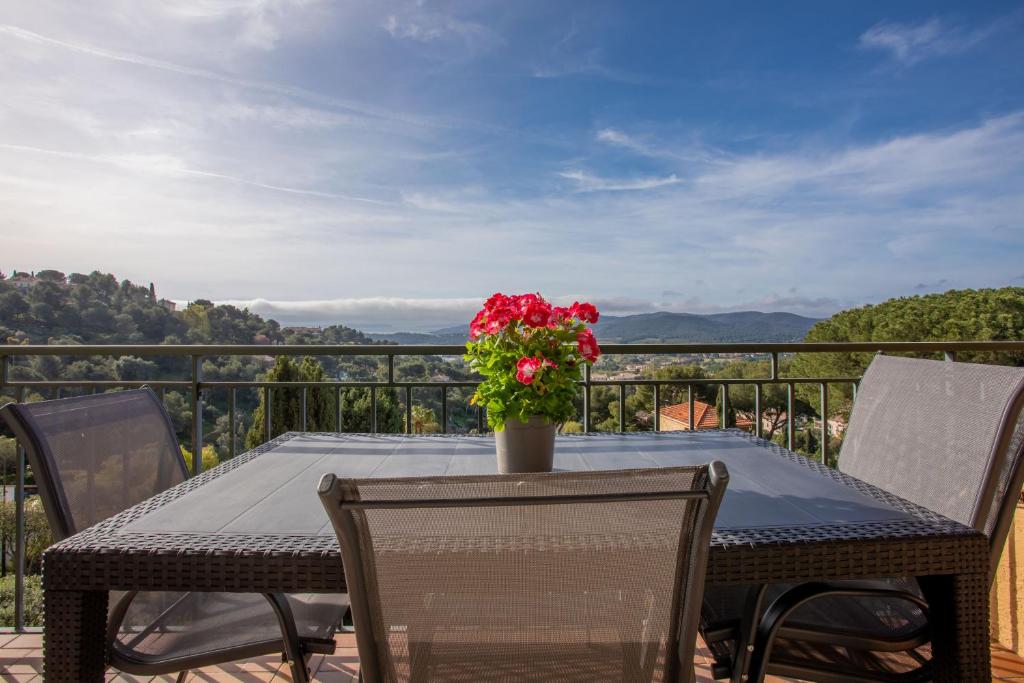 une table avec un vase de fleurs sur un balcon dans l'établissement Le Mas Berliat F2 N°16, à Bormes-les-Mimosas
