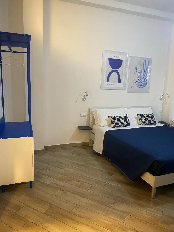 a bedroom with a bed with a blue comforter at DOMOBLU Camere In Centro in Tortolì