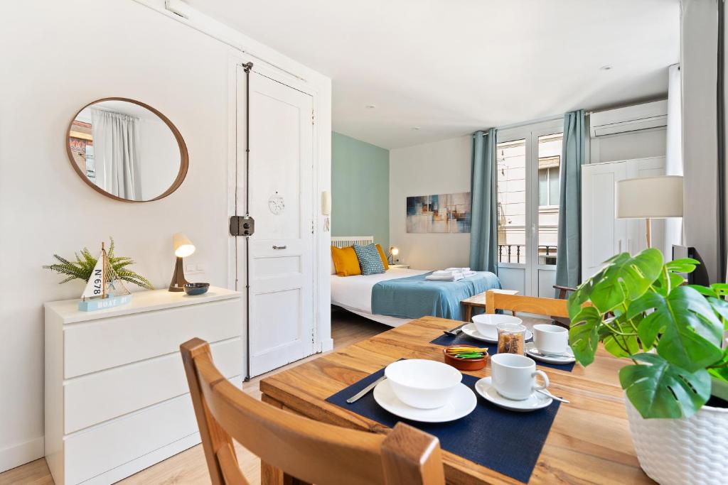 a dining room with a table and a bedroom at Lodging Apartments Barceloneta Beach Studio 31 in Barcelona