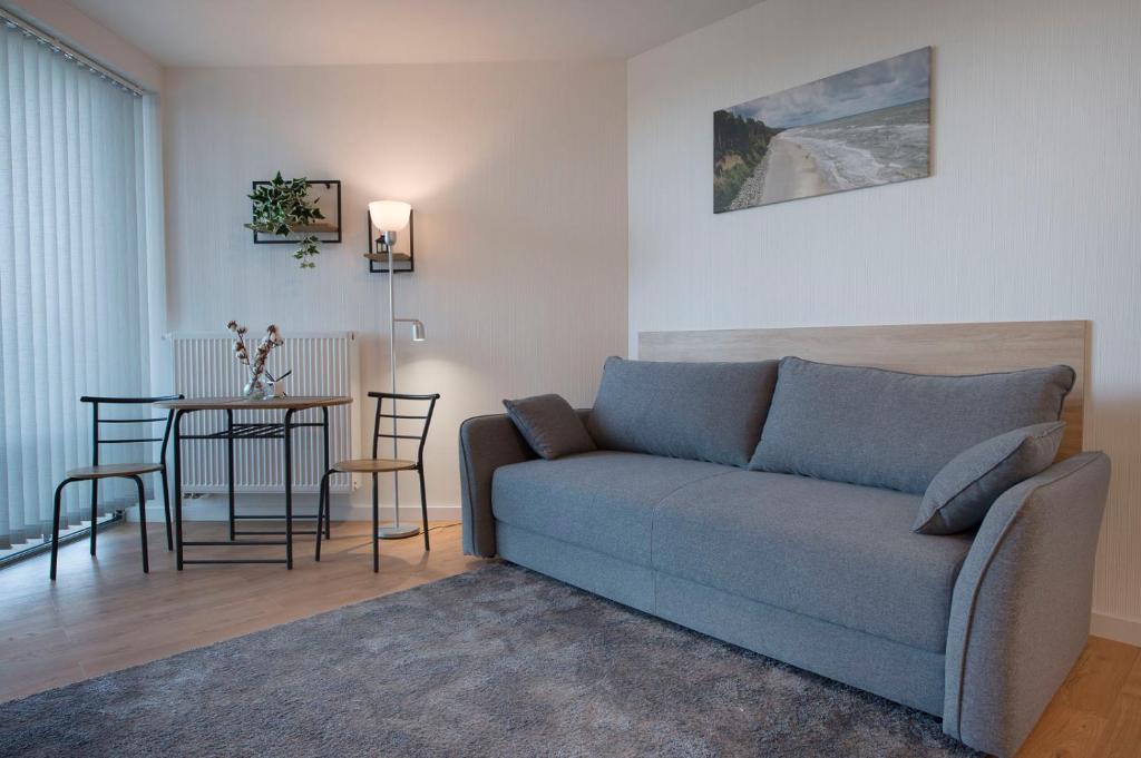 uma sala de estar com um sofá e uma mesa em Apartament Deluxe Sea View PINEA 621 em Pobierowo