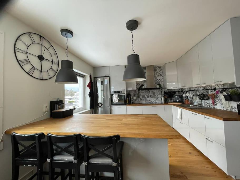 a large kitchen with a large clock on the wall at Turnus? Leilighet nær Ahus til leie in Lorenskog