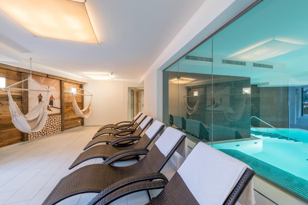 - une rangée de chaises dans une chambre avec piscine dans l'établissement A Casa Saphir Appartement-Hotel, à Sölden
