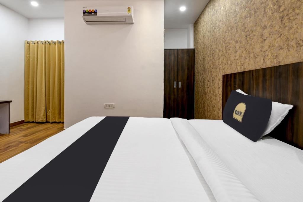 a bedroom with a bed with a black and white comforter at Townhouse OAK Armeria in Lucknow