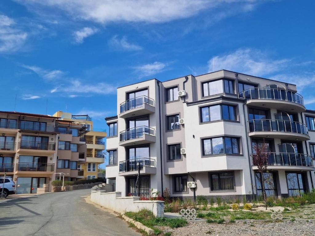 an apartment building with balconies on a street at HIMS APARTMENTS in Sozopol