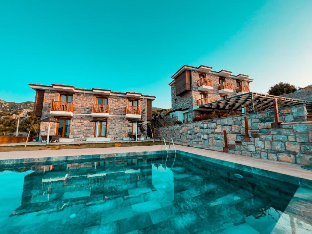 uma villa com piscina em frente a um edifício em Alice Tatil Evi em Marmaris