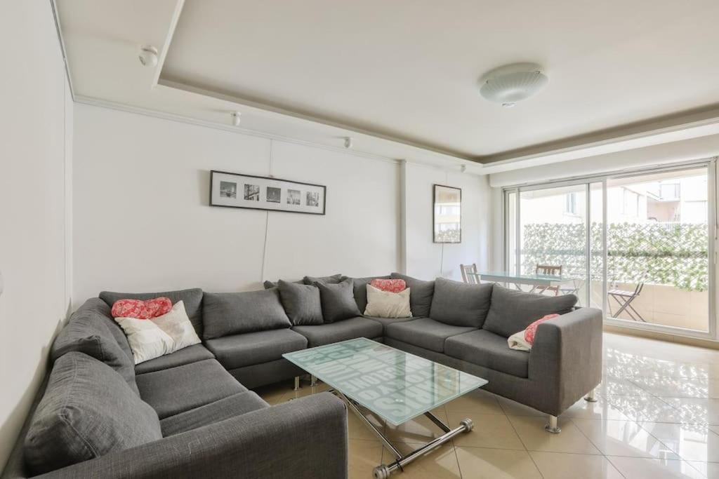 un salon avec un canapé et une table en verre dans l'établissement Cosy appart avec balcon Pont de Flandres - Crimée, à Paris