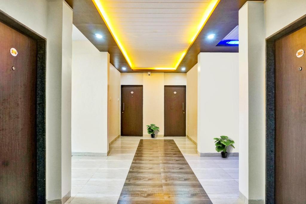 a hallway in a building with two plants at Hotel Eon Inn Near Pune Airport in Kharadi