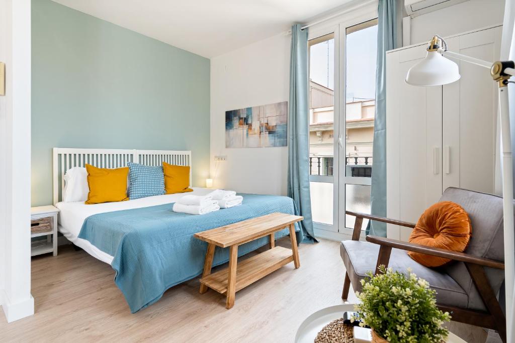 a bedroom with a bed and a table at Lodging Apartments Beach Studio 41 in Barcelona