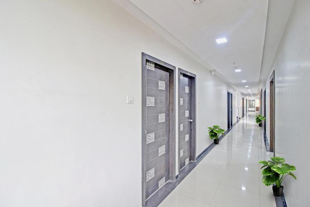 a corridor of a hospital with potted plants at Collection O Hotel Raj Mahal in Turambhe