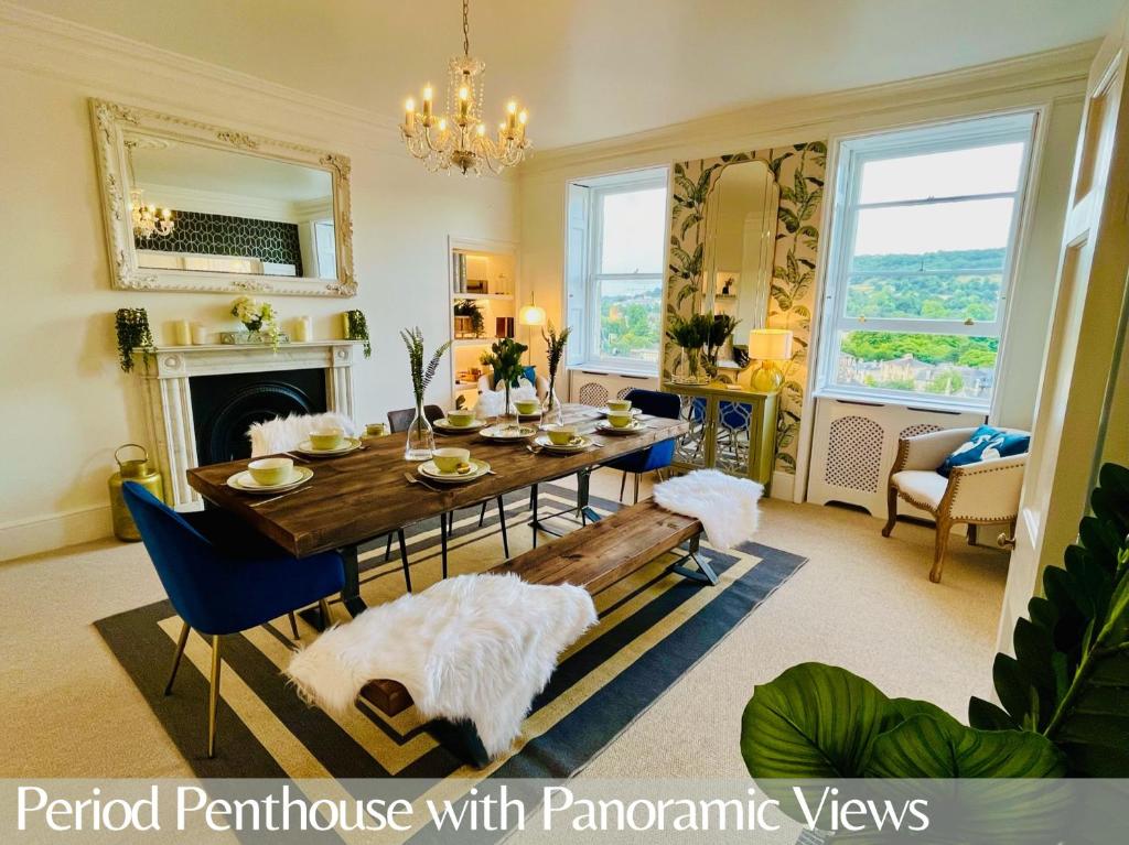 ein Esszimmer mit einem Tisch und einem Kamin in der Unterkunft The Paragon Penthouse - Stunning Views over Bath! in Bath