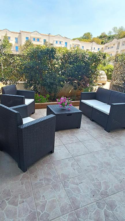 a patio with couches and a table and flowers at Casetta Pinetamare Tropea in Tropea