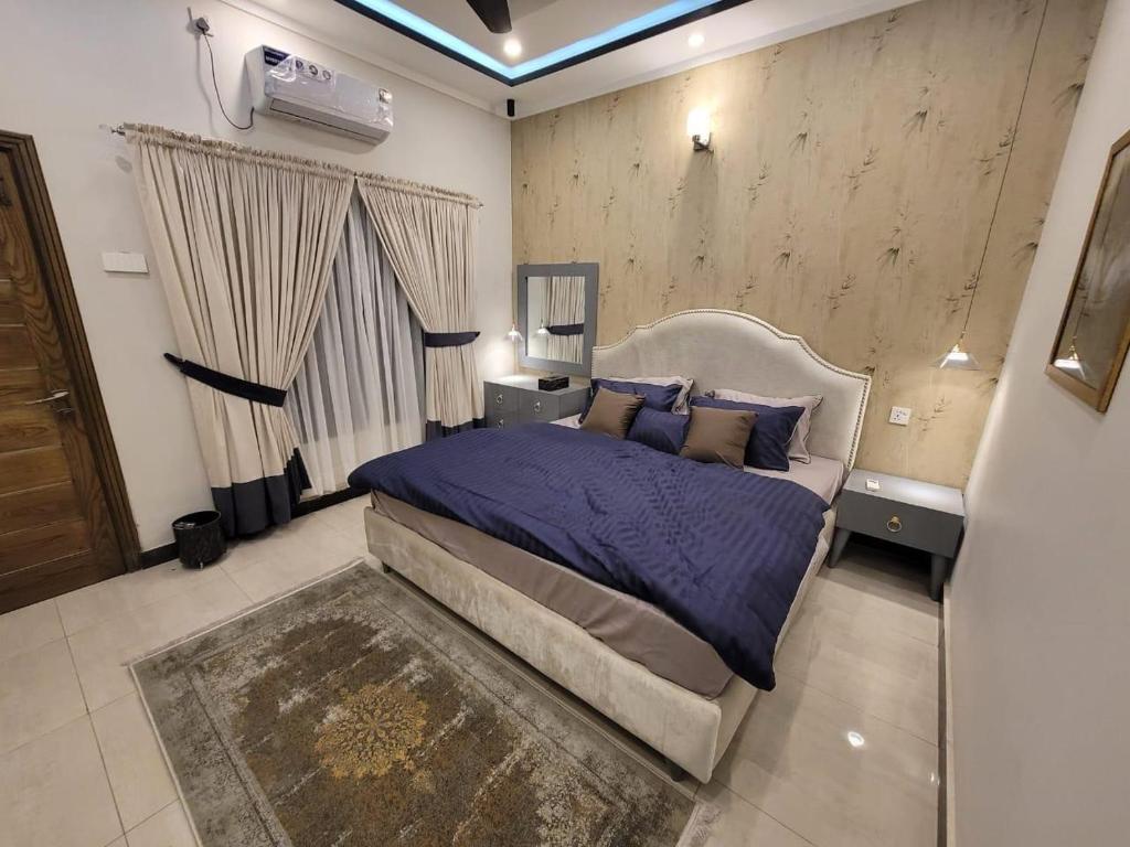 イスラマバードにあるedge villasのベッドルーム1室(紫のシーツが敷かれたベッド1台、窓付)