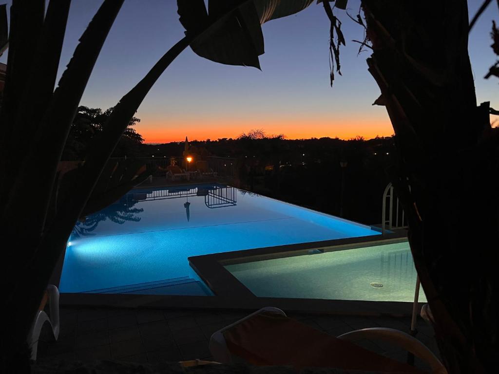 - une vue sur la piscine au coucher du soleil dans l'établissement Vale da Pinta Golf, à Estômbar