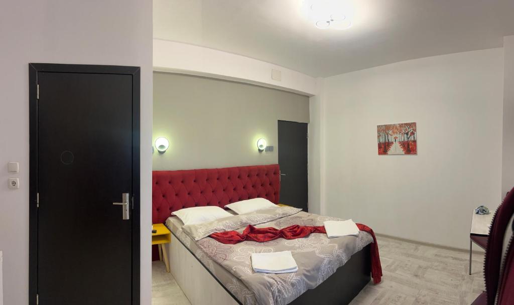 1 dormitorio con 1 cama con cabecero rojo en Pensiunea Liziera 1 en Buşteni
