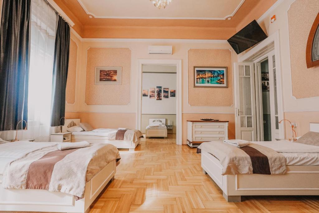 a bedroom with two beds and a wooden floor at Unio Apartment in Budapest