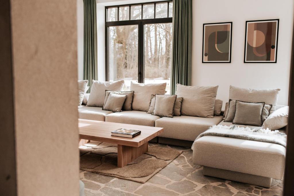 a living room with a couch and a table at Vakantiewoning Domein Hooverbosch in Zonnebeke