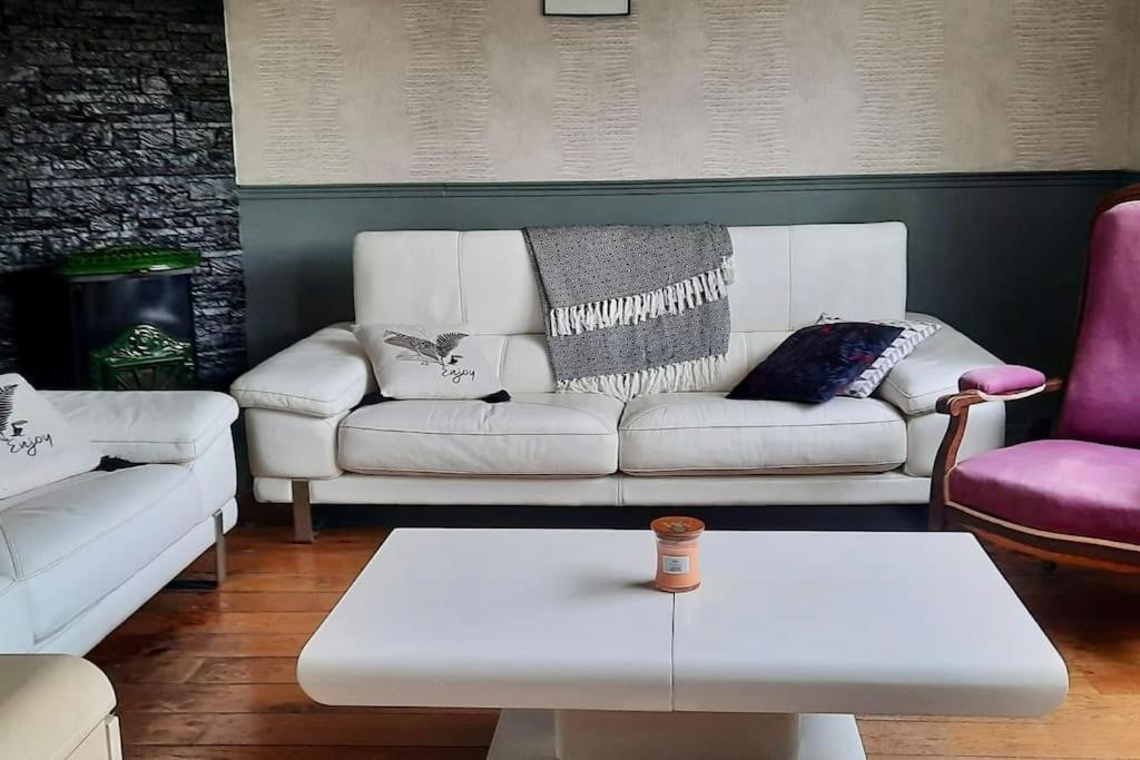 Sala de estar con sofá blanco y mesa de centro en La Maraitière, en Guînes
