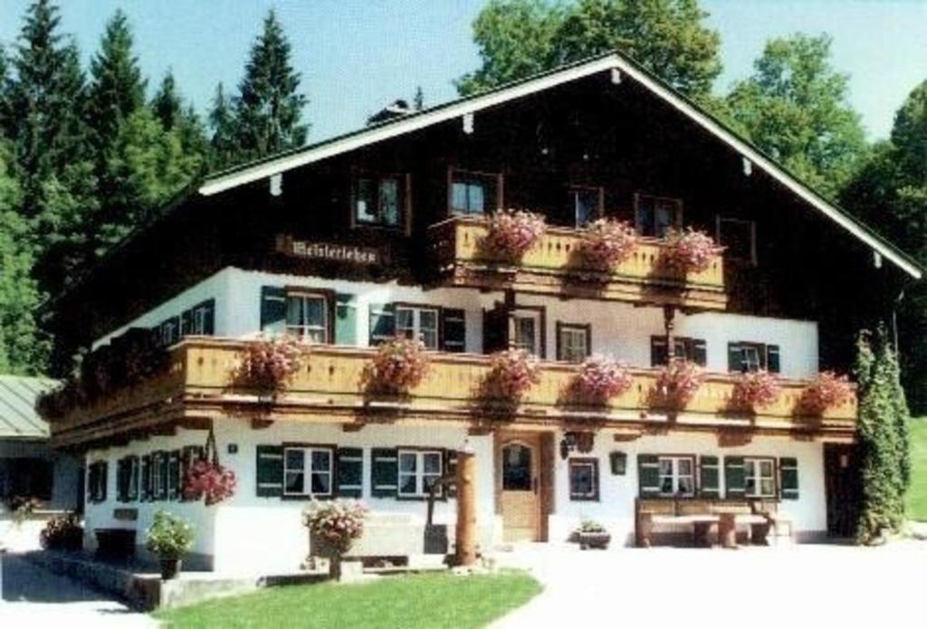 ein großes Haus mit Blumentopfen oben drauf in der Unterkunft Wohnung in Unterschönau mit Grill in Schönau am Königssee