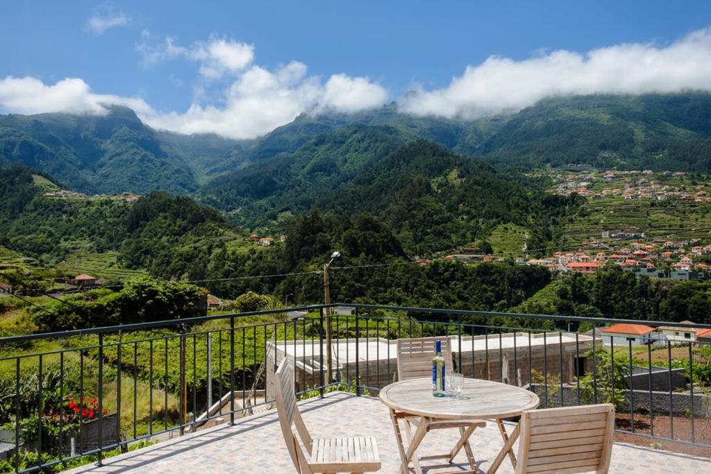 uma mesa e cadeiras numa varanda com montanhas em GuestReady - Panoramic Mountain Escape em São Vicente