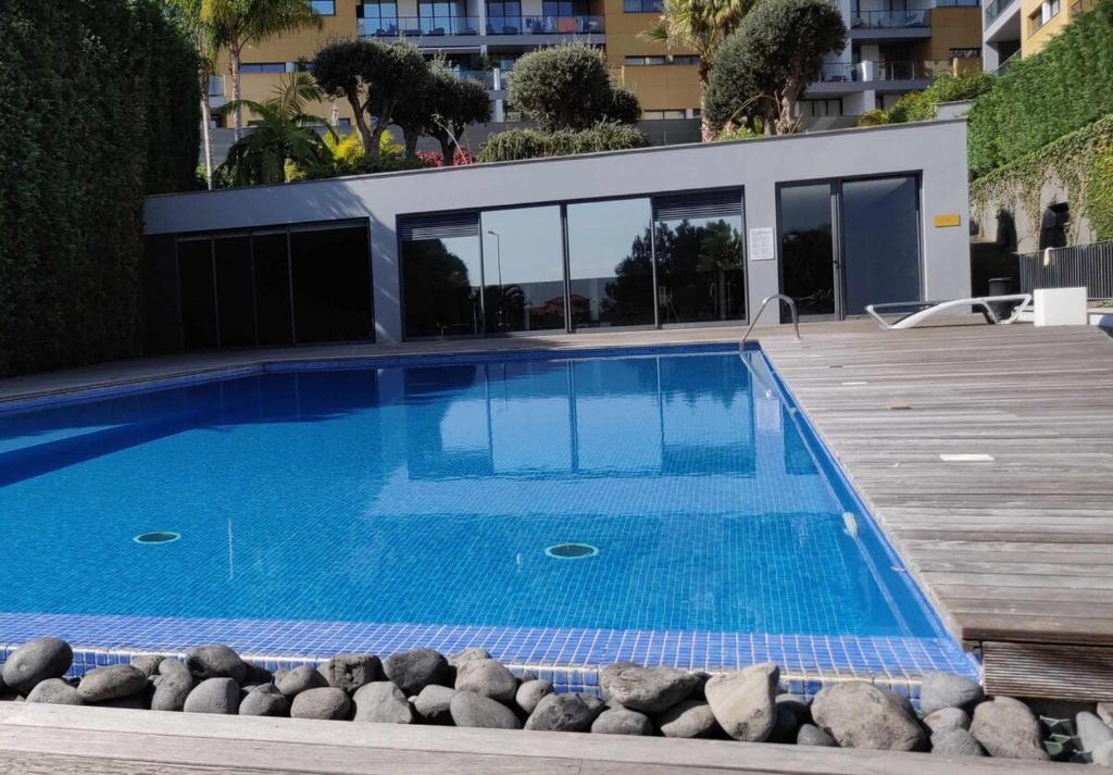 a swimming pool on a deck next to a building at Condomínio Zen Pearl-Luxury com piscina in Funchal