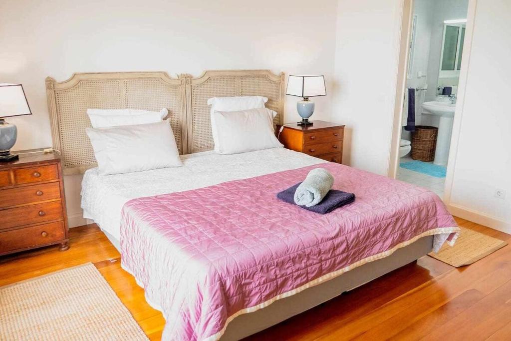 1 dormitorio con 1 cama grande con manta rosa en Vila da Falésia-With Pool and views en Caniço