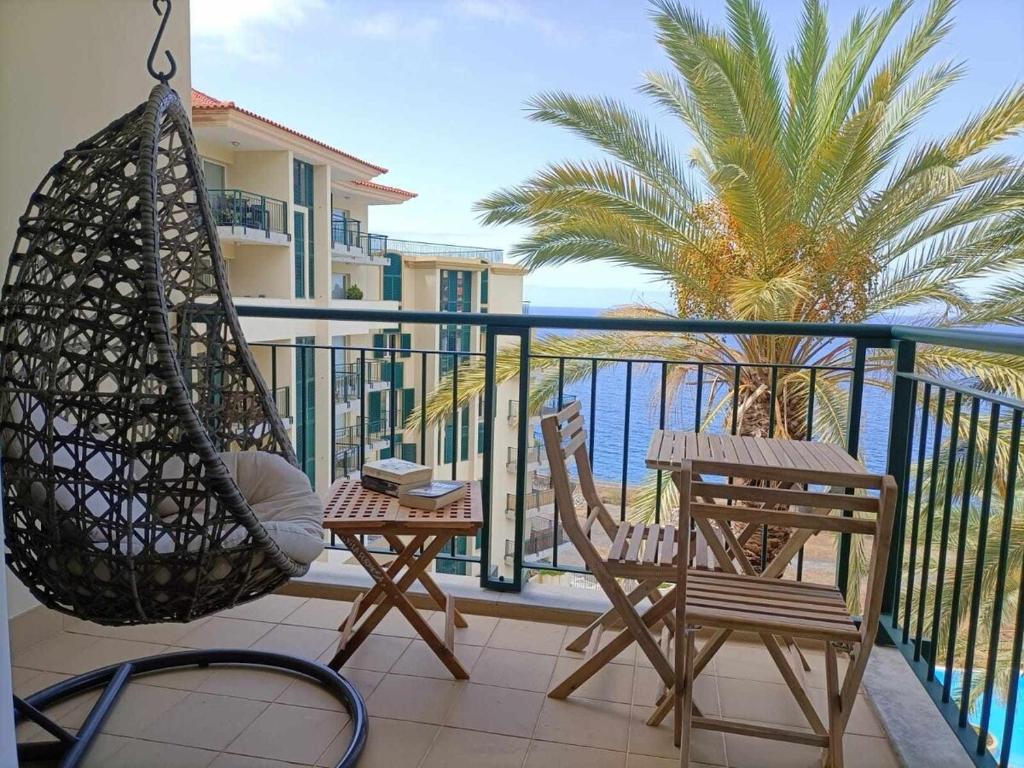 a porch with a hammock and chairs on a balcony at GuestReady - Vila Formosa in Funchal