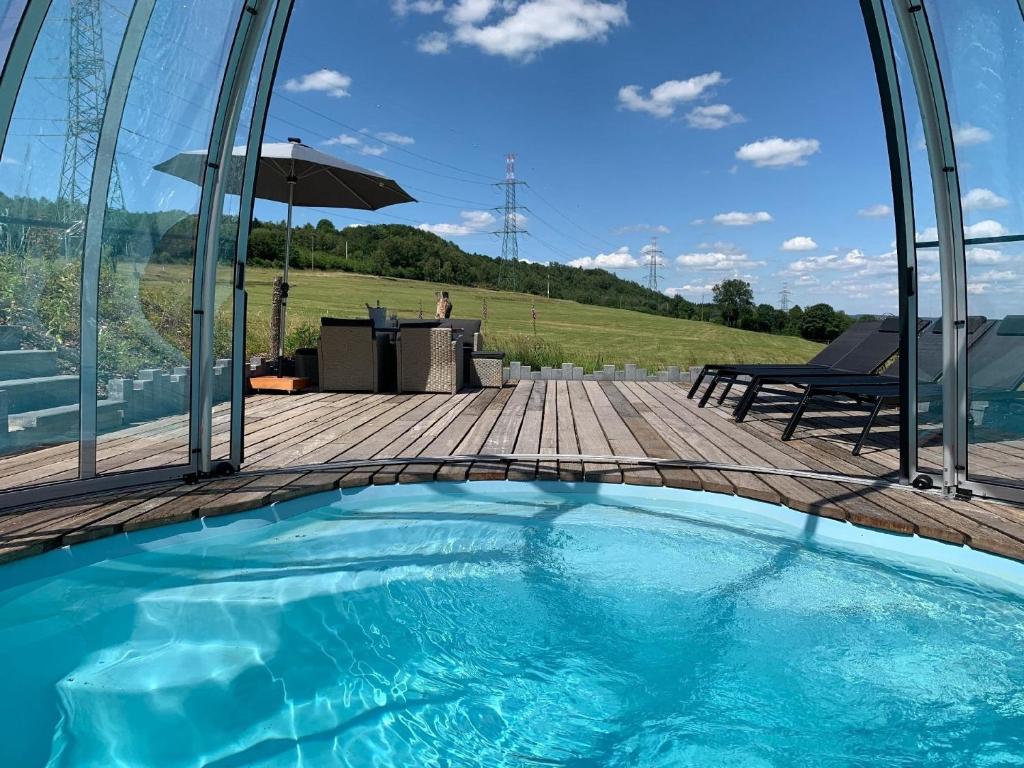 einen Pool mit Blick auf einen Tisch und einen Sonnenschirm in der Unterkunft Ferienhaus mit Privatpool für 4 Personen ca 120 m in Trois-Ponts, Wallonie Spa-Francorchamps und Umgebung in Trois-Ponts