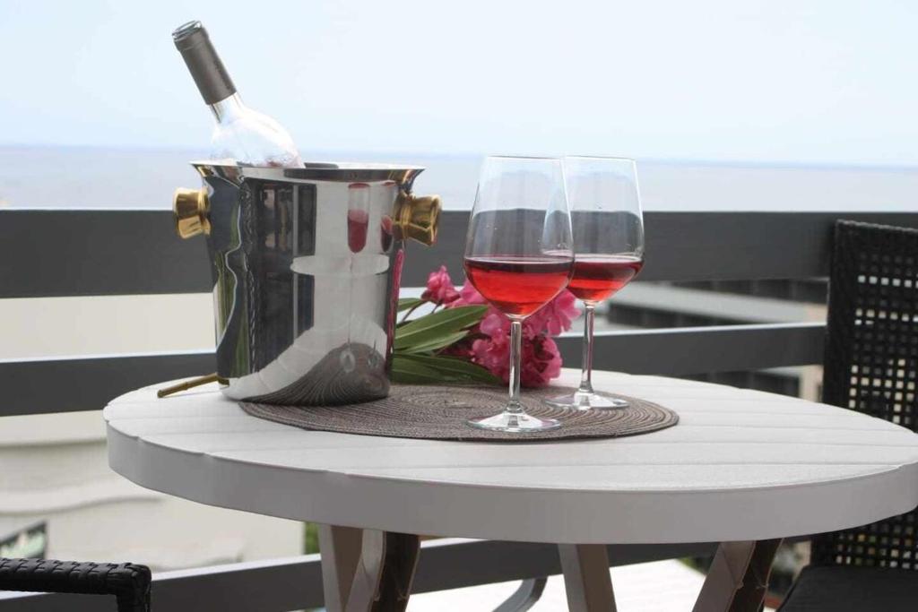 een tafel met twee glazen wijn en een tas bij Lido Mar - Hotels area in Funchal