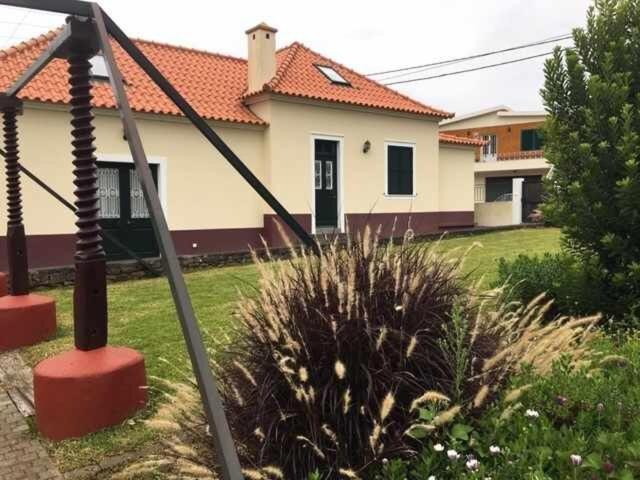 una casa con un cortile con una casa di GuestReady - Casa Avó Alice a Porto da Cruz