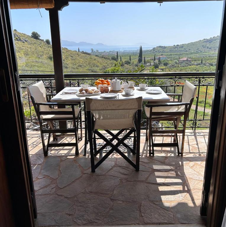 a table and chairs on a patio with a view at Pontinos Villa in Myloi