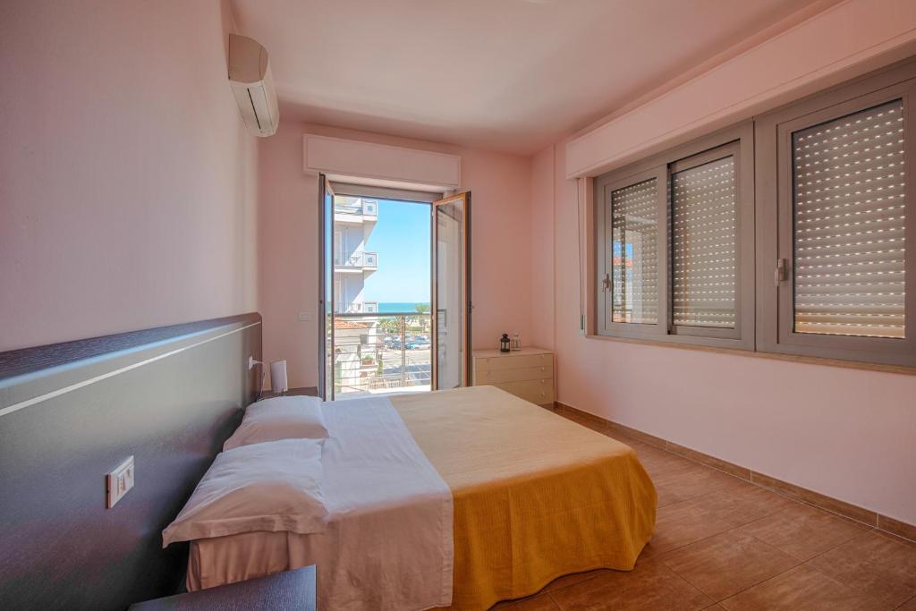 a bedroom with a bed and a large window at Residence Palazzo Gasparroni in Tortoreto Lido