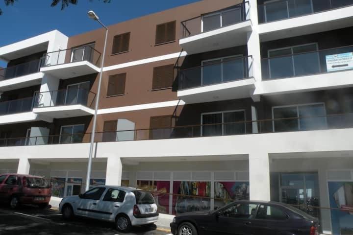 two cars parked in a parking lot in front of a building at GuestReady - Tamariz Cosy Stay in Caniço