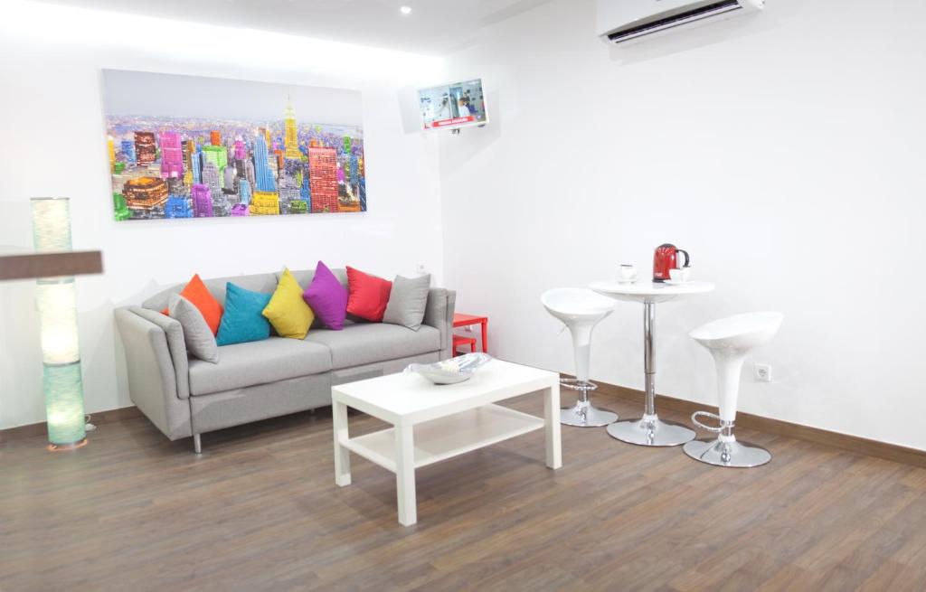 a living room with a couch with colorful pillows at Color Suites Alicante in Alicante